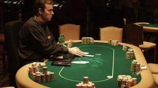 Un croupier à une table de poker live, pendant que les joueurs sont absents (en pause). Un croupier à une table de poker live.