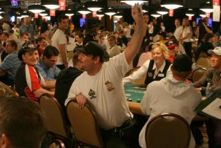 Joueur de poker qui lève la main à la table