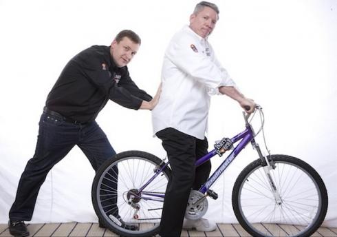 Tony G faisant sembler de pousser Mike Sexton sur un vélo. Velo de Tony G