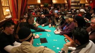Le croupier ramasse les mises des joueurs à une table de poker