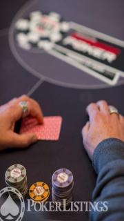 Joueur de poker qui semble prêt à jeter ses cartes